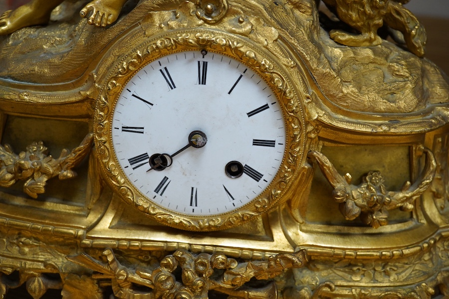 An early 20th century French ormolu clock surmounted with a boy and dog, striking on a bell, 41cm wide. Condition - fair, one hand missing, untested